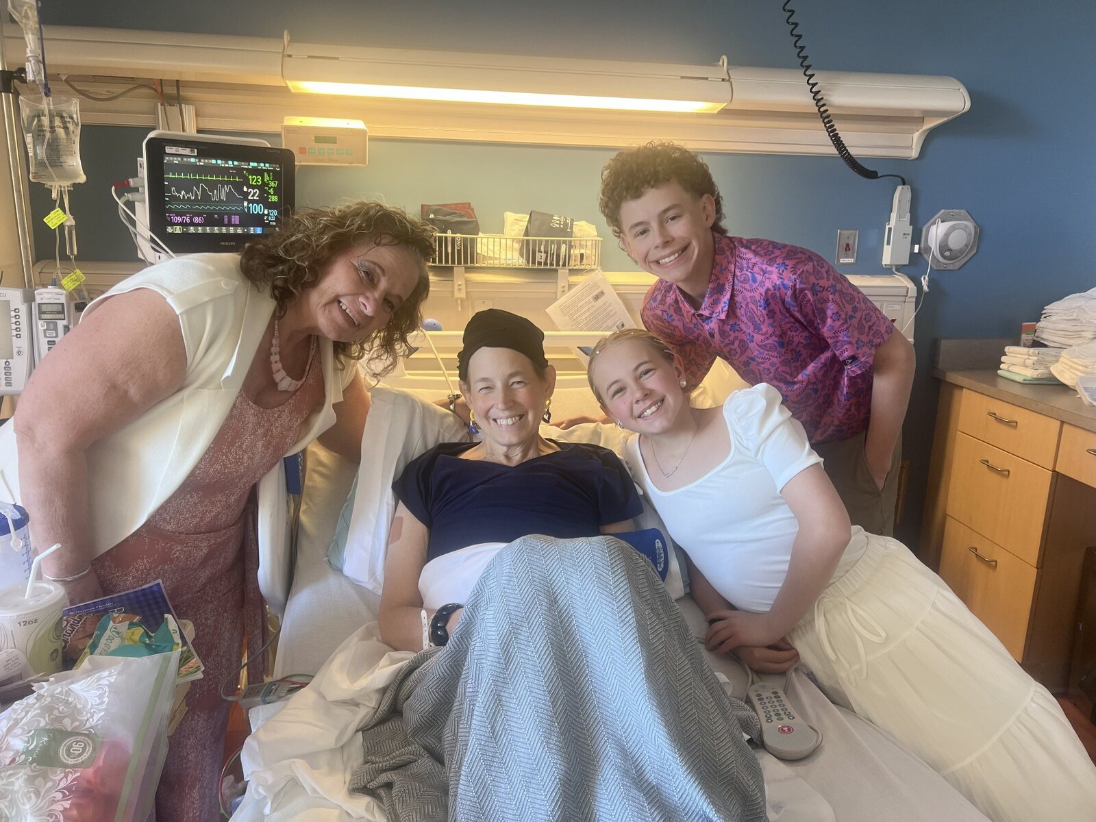 Irish smiling in the hospital surrounded by her children and family